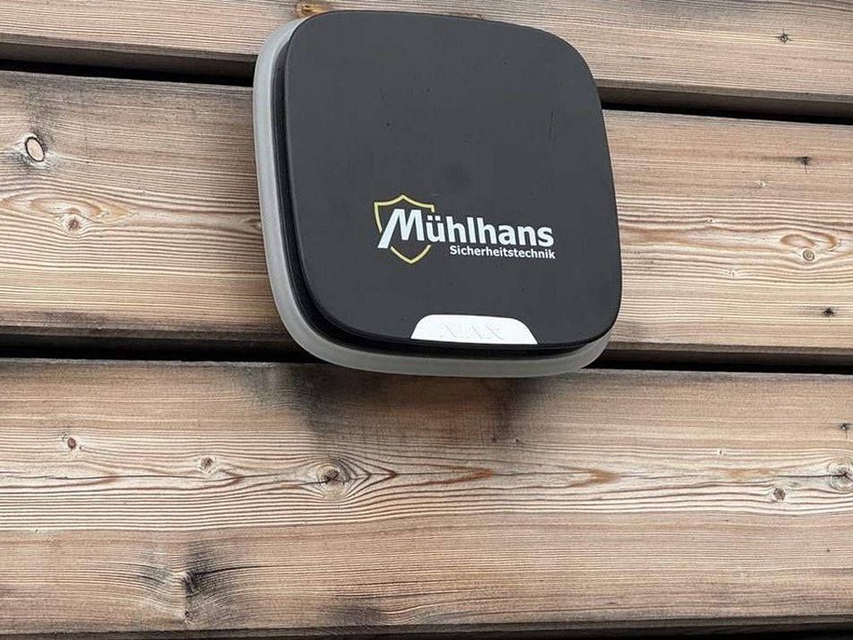 Außensirene mit Mühlhans-Logo an Holzfassade